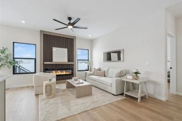 Modern living room with fireplace and neutral decor.