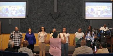 Choir performing in a church with a conductor and audience.