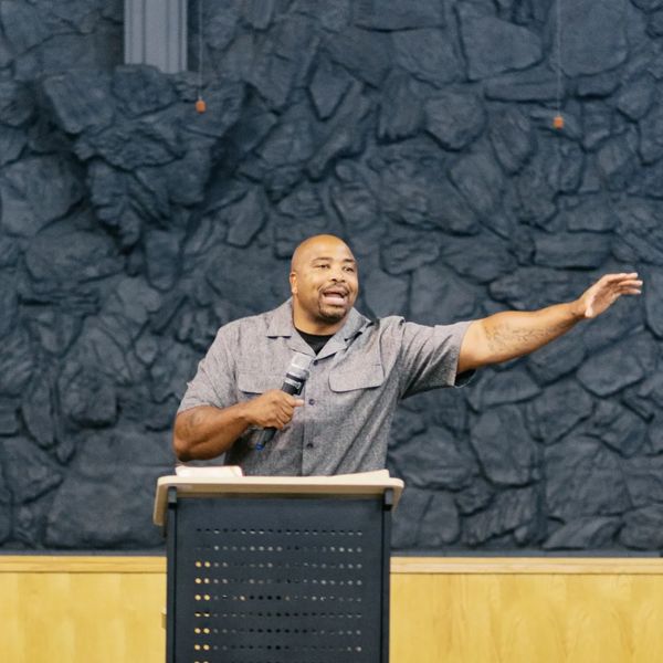Man speaking passionately behind a podium with a microphone.