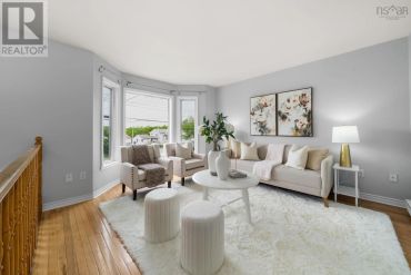 Bright living room with gray walls and white furniture.