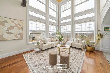 Bright living room with large windows and modern furniture.