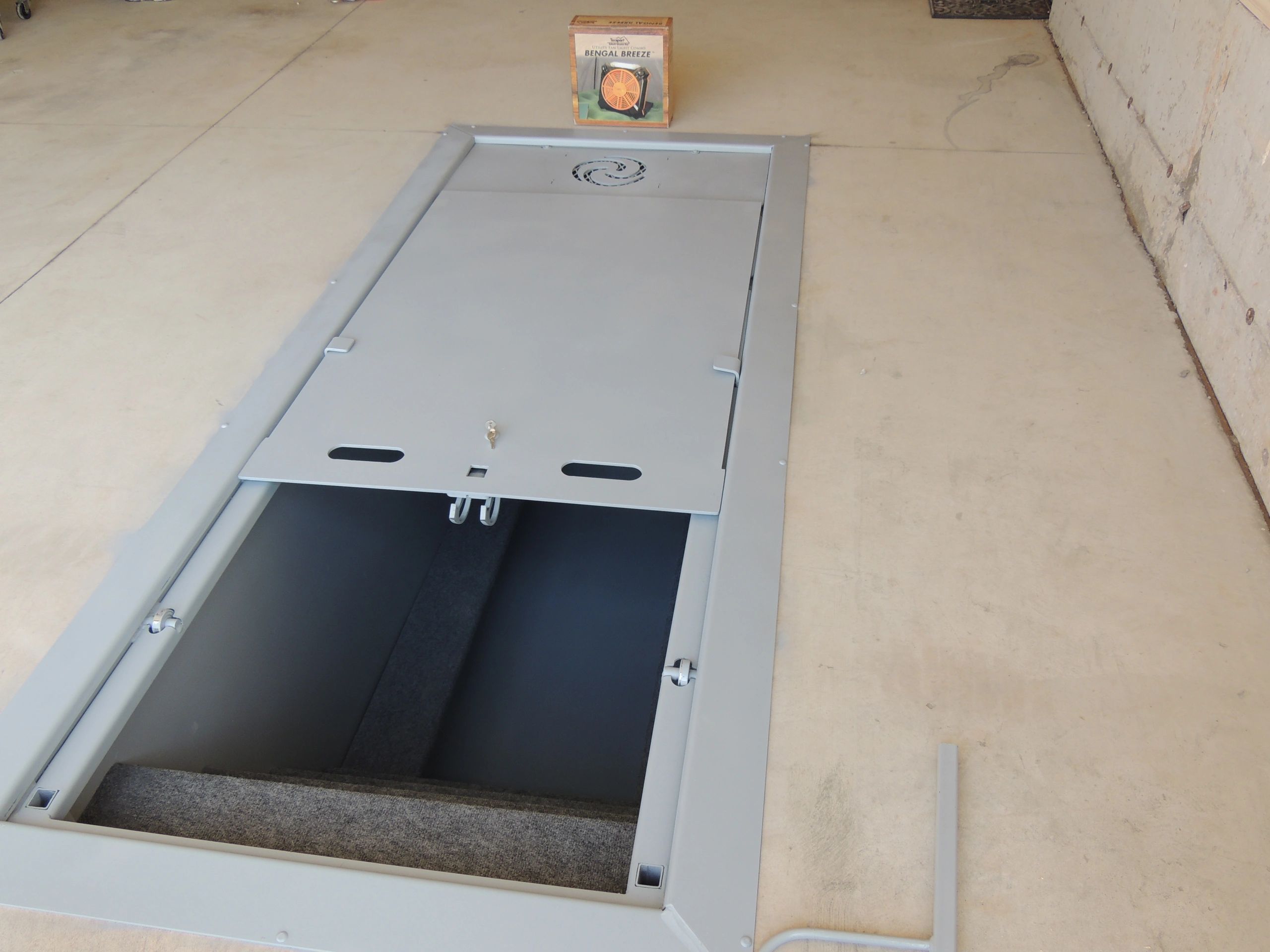 An inground tornado shelter installed in a kentucky garage.  Installed by Hoptown Storm Shelters.