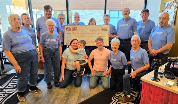 Group of people presenting a large check at Pizza Ranch.