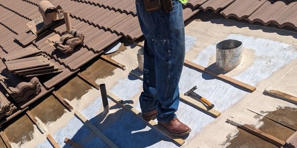 Employee repairing a tile roof