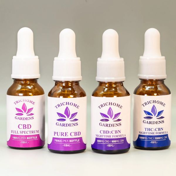 Four CBD and THC tincture bottles from Trichome Gardens with white droppers.
