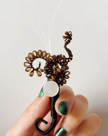 Brooch made from human hair, cat whiskers and mother of pearl button