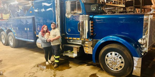 Henry and family standing next to Big Bulldog Towing’s new Peterbilt 379 35-Ton Blue Heavy Wrecker
