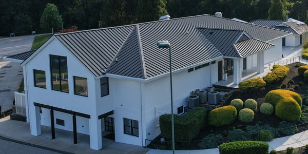 A modern white building named 'Chateau' surrounded by landscaped gardens and greenery.