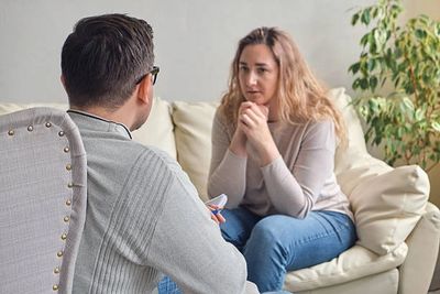 A woman talks to a therapist in a counseling session.