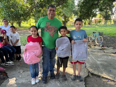 Children receiving new backpacks