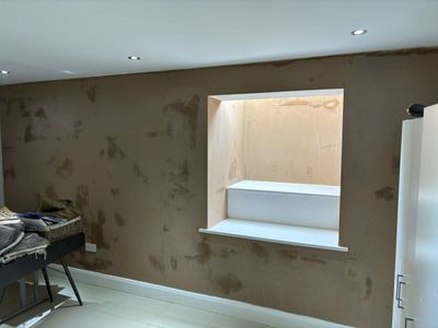 Interior wall with a recessed window and a brown textured finish.