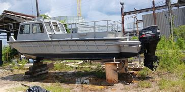 Small motorboat on dry land with a Suzuki outboard engine.
