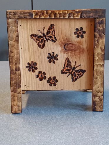 Wooden frame with burnt butterfly and flower designs.
