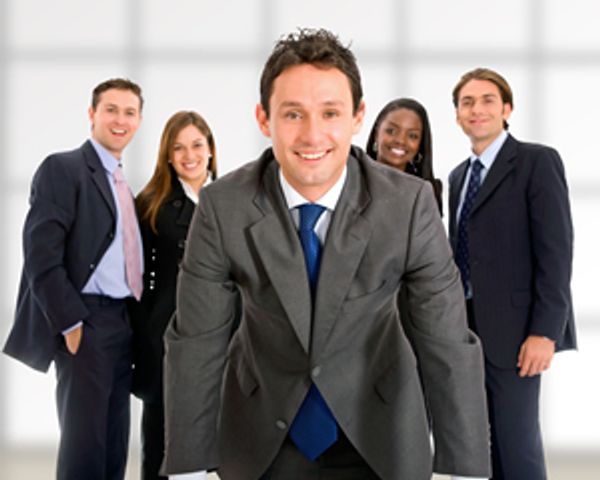 Smiling businessman in front of four colleagues.







