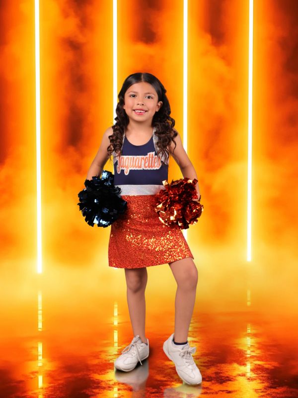 Young cheerleader with pom-poms and sparkly skirt.