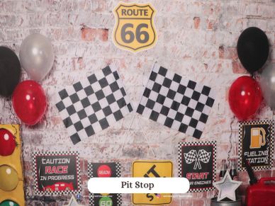 Race-themed pit stop setup with checkered flags and balloons.