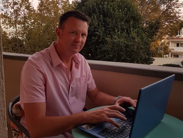 Portrait of a young man sitting at his desk working on his laptop 