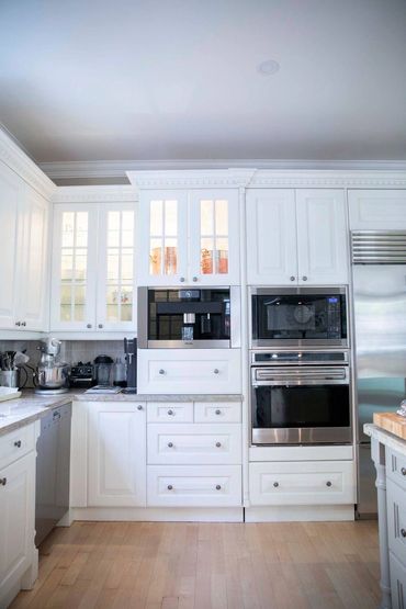 White custom cabinetry with crown millwork & integrated appliances in a luxury Ontario kitchen.