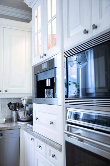 White custom cabinetry with crown millwork & integrated appliances in a luxury Ontario kitchen.