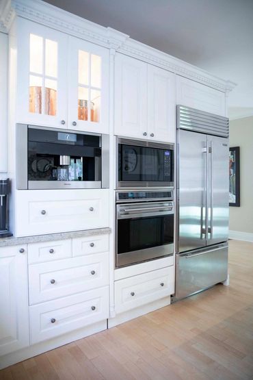 White custom cabinetry with crown millwork & integrated appliances in a luxury Ontario kitchen.