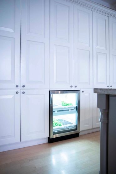 White custom cabinetry with crown millwork & integrated appliances in a luxury Ontario kitchen.