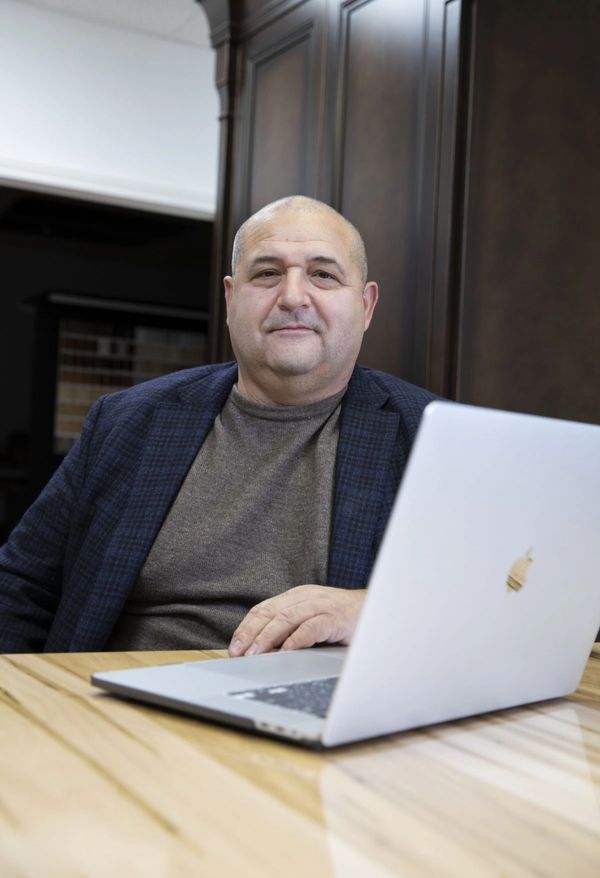 Jose De Sa, President and Founder of TKB Group, sitting at a desk in front of a MacBook.