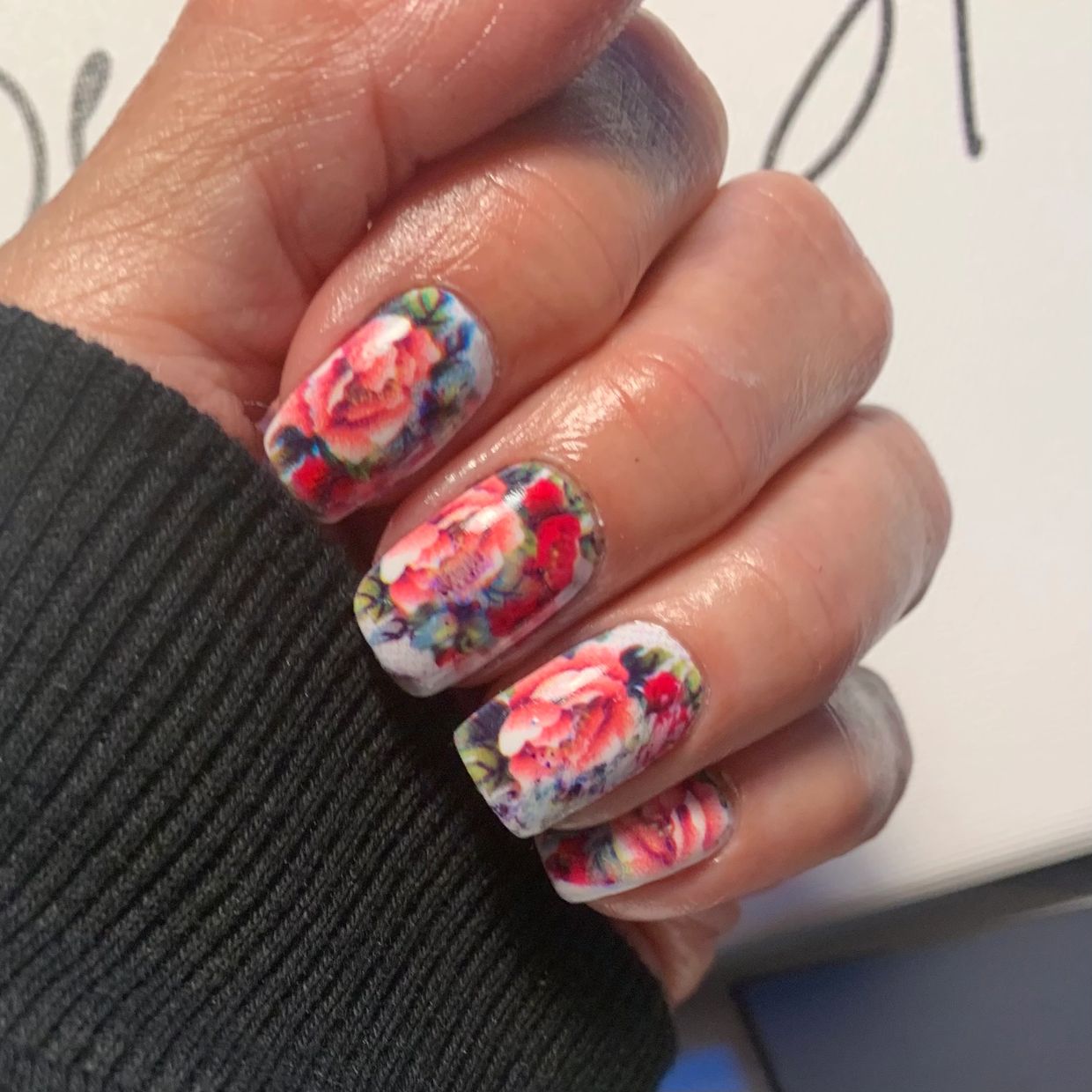 Hand with red rose floral nail art on Fingernails