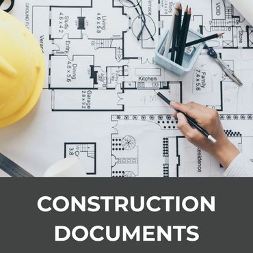 Architect working on construction blueprints with tools and a hard hat nearby.