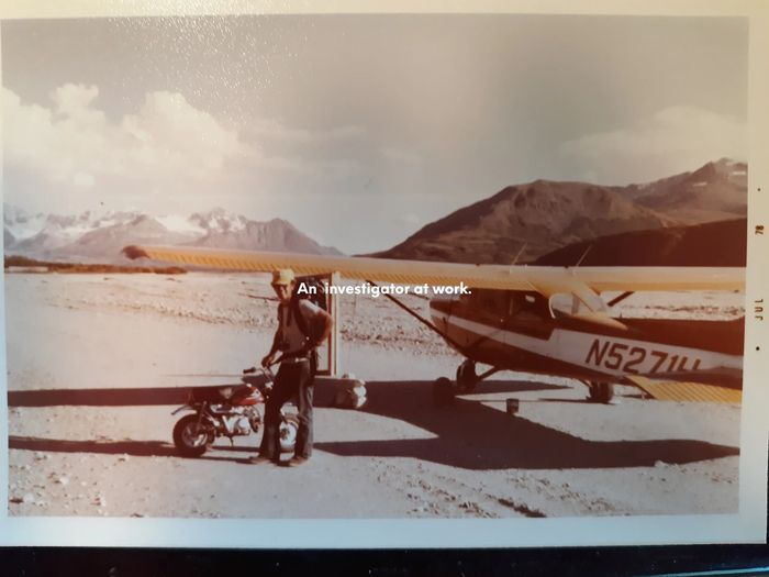 Leroy Cook standing by a Honda mini bike and an airplane near Chicken Alaska.