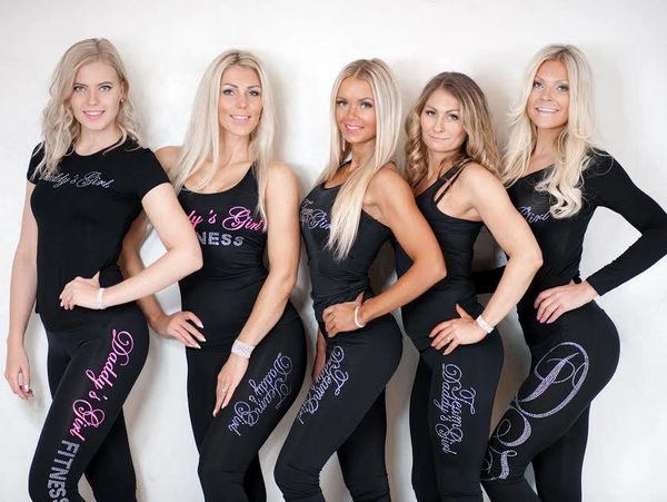 Five women in black fitness outfits posing.