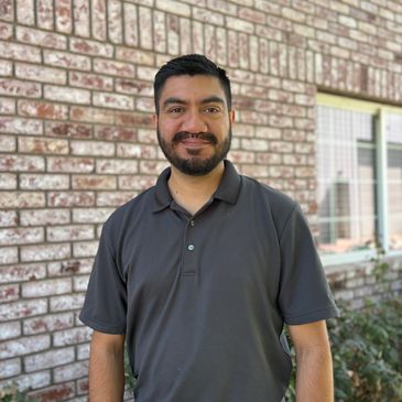 Picture of Kane; Looking straight at camera, dark hair, short dark beard, smiling, showing no teeth.e