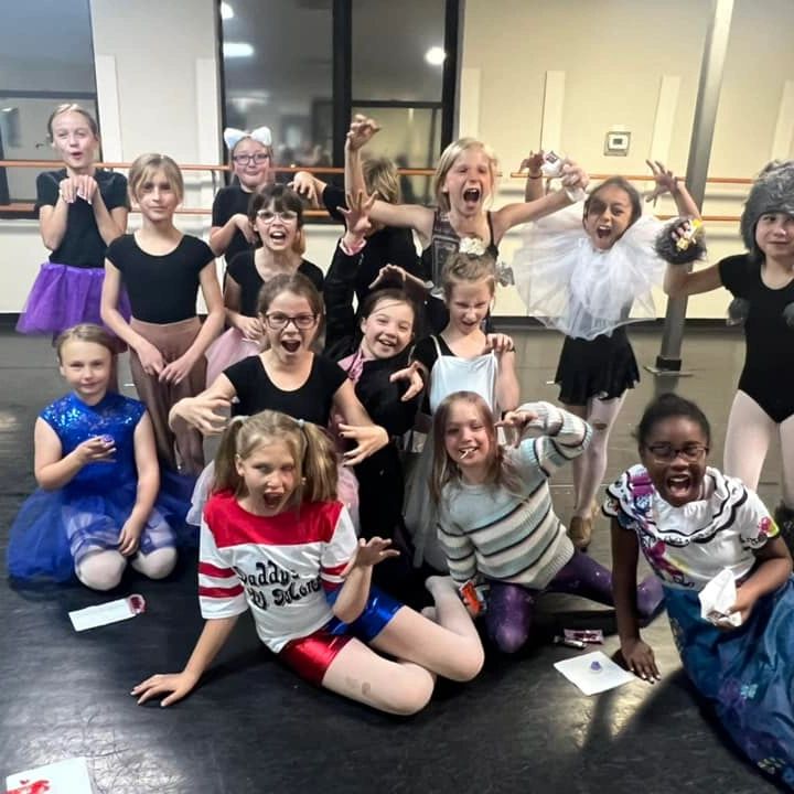 Group of children in costumes making playful scary faces.