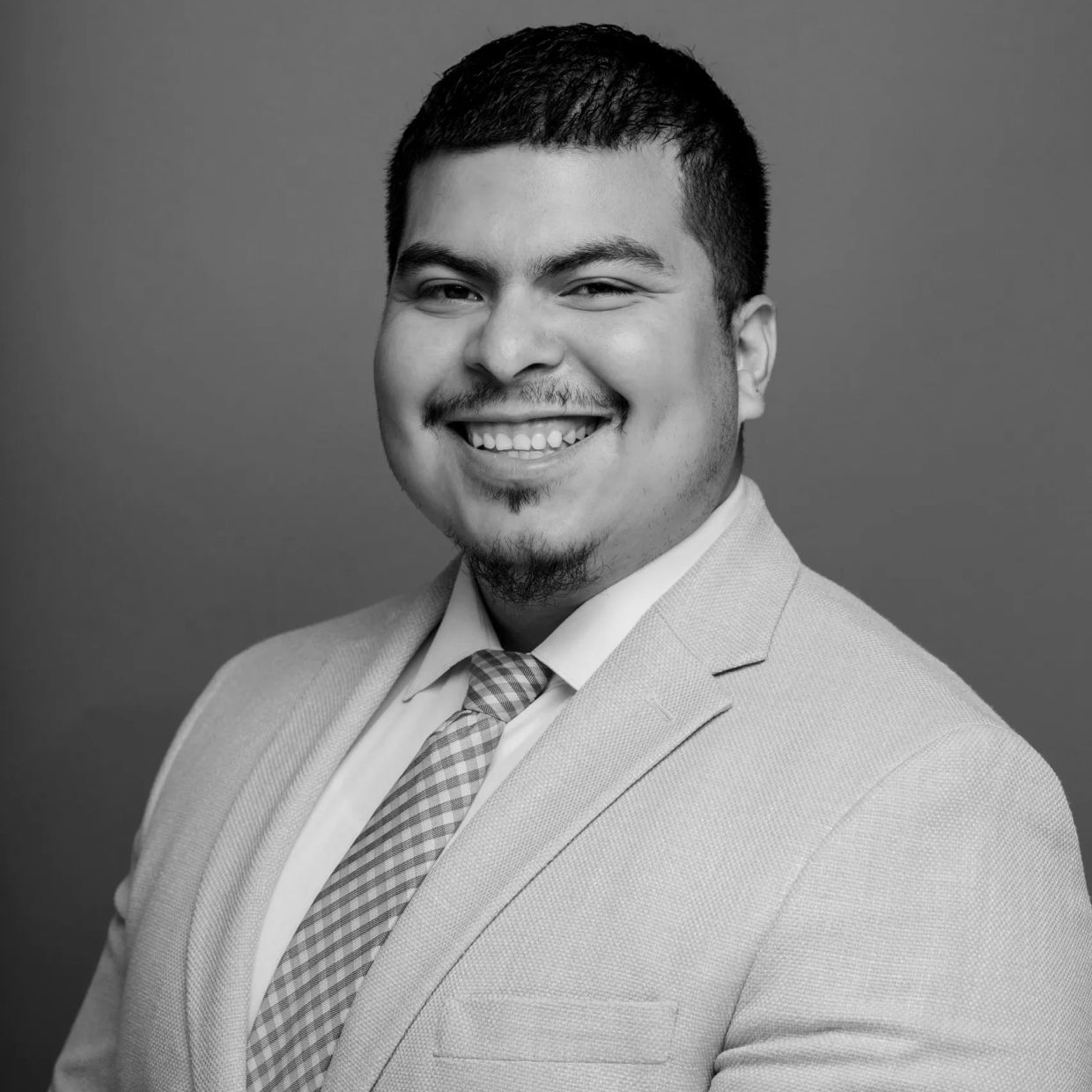 Smiling man in suit and tie.