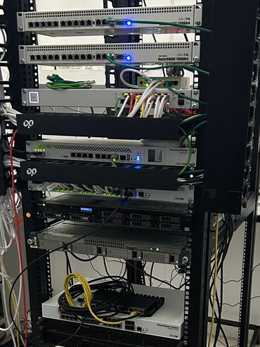 A rack filled with network switches and servers connected by various cables.