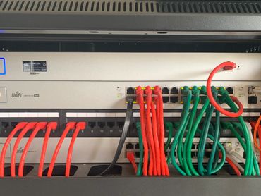 Network switch with organized red and green Ethernet cables connected.