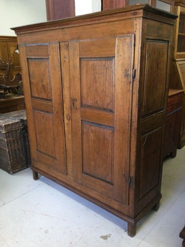 Antique wooden cabinet with paneled doors and a rustic finish.