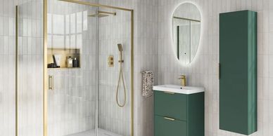Modern bathroom with glass shower, green cabinets, and gold fixtures.