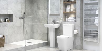 Modern gray bathroom with walk-in shower, pedestal sink, and toilet.