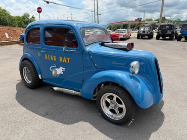 Classic blue hot rod car named 'King Rat' with custom hood scoop and racing wheels.