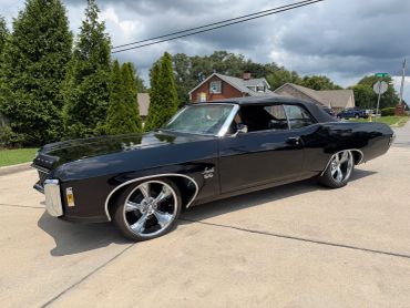 Black classic convertible car parked on driveway.