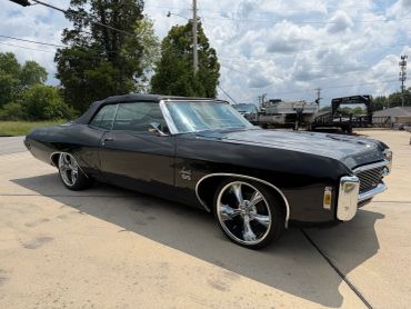Black classic convertible car with shiny chrome rims.