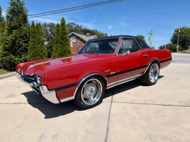 Red classic convertible car parked on a driveway.