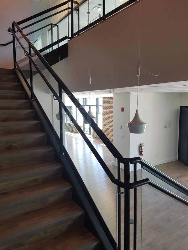 Modern indoor staircase with wooden steps and glass railings.