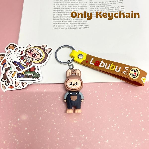 Cute Labubu keychain with cartoon stickers on a pink surface.
