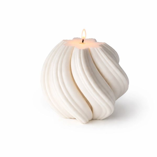 White sculptural candle with flowing, curved design and a small flame.