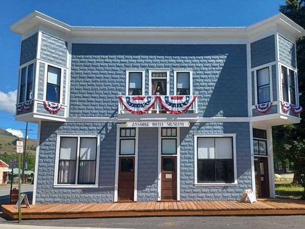Historic gray building with patriotic decorations.