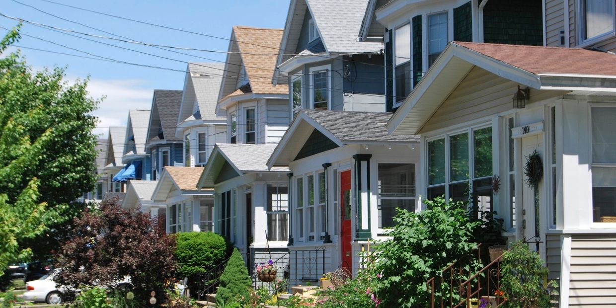 Row of charming suburban houses with varied roof styles and front porches.