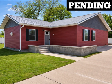 New red house with a small concrete porch and green lawn.
