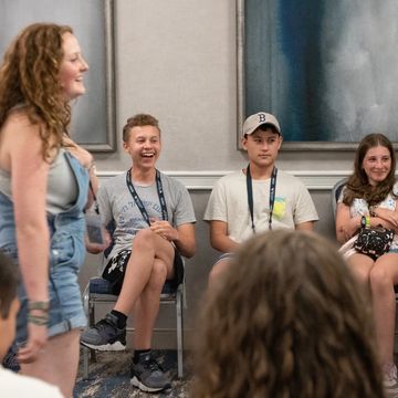 Teens engaged in a group activity, sharing laughter and attentiveness indoors.
