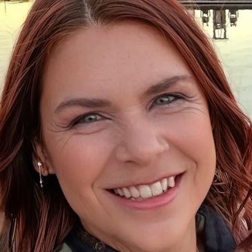 Woman with red hair smiling close-up.